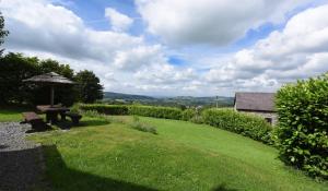 a picnic table and an umbrella in a field at Rhiwddu Barns in Llangadog