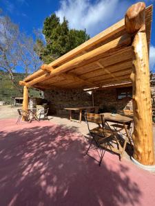 a wooden pergola with a picnic table and chairs at Chambres d'hôtes Gîte Saint Roch in Tuchan