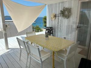 a table and chairs on a deck with the ocean at BUQEZ ECO RESORT - Beach Villas 2 and 8 - Seaview, new wifi! in Drage