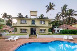 a house with a swimming pool in front of a house at Casa Legend Economy, Calangute Goa in Candolim
