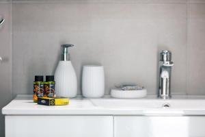 a white kitchen counter with a sink and vases at Estia Comfort House in Chania +32 photos