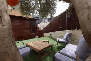 a backyard with a table and chairs and a wooden table at Mary's Well Apartments in Nazareth