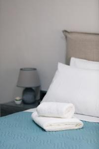 a bed with two towels sitting on top of it at Estia Comfort House in Chania