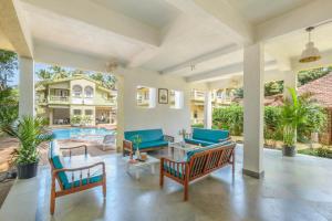 un soggiorno con mobili blu e una piscina di Casa Legend Economy, Calangute Goa a Candolim
