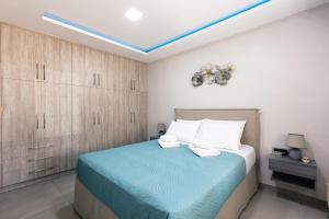 a bedroom with a bed with a blue blanket at Estia Comfort House in Chania