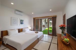 a hotel room with two beds and a television at BIG & PRIVATE 9 BED, 9 BATH, Viola Villa, POOL, Best Location in Seminyak