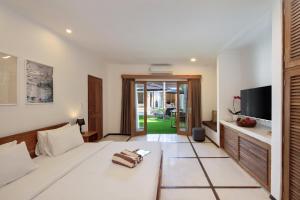 a living room with a bed and a television at BIG & PRIVATE 9 BED, 9 BATH, Viola Villa, POOL, Best Location in Seminyak