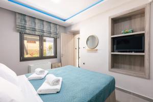 a bedroom with a bed and a tv and a window at Estia Comfort House in Chania
