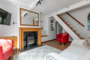 ein Wohnzimmer mit einem Kamin und einem roten Stuhl in der Unterkunft Stylish 2BD Family Hideaway in Dover in Dover