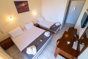 Cette petite chambre comprend un lit et une table. dans l'établissement Iraklis Hotel, à Mitikas