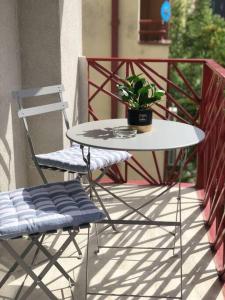 una mesa y una silla en un balcón con una maceta en DreamLux DM With Parking, en Skopje