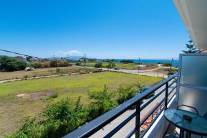 a balcony with a view of a field and the ocean at Iraklis Hotel in Mitikas