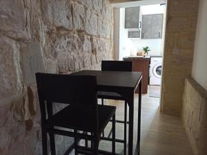 ein Esszimmer mit einem schwarzen Tisch und Stühlen in der Unterkunft Beautiful 1-Bed Apartment in Hal Qormi in Qormi