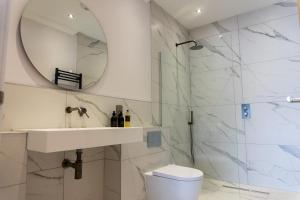 a bathroom with a shower and a sink and a mirror at Oban Apartments in Oban