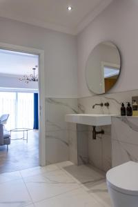 a white bathroom with a sink and a mirror at Oban Apartments in Oban