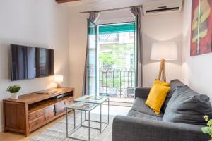 a living room with a couch and a tv at Feelathome Center Apartments in Barcelona