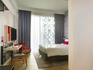 een hotelkamer met een bed, een tafel en een bureau bij IntercityHotel Muscat in Muscat