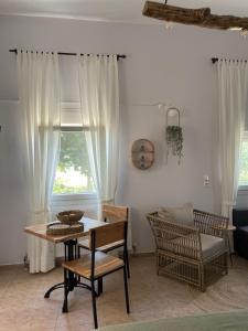 a living room with a table and chairs and a window at Platanos in Samothráki