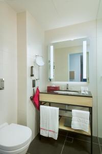 a bathroom with a sink and a toilet and a mirror at IntercityHotel Muscat in Muscat