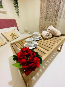 a wooden table with a bouquet of red roses on it at Azahar house in Formentera del Segura