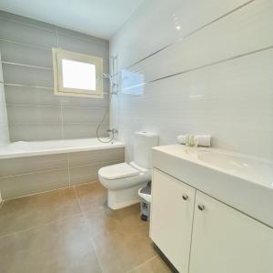 Un baño blanco con inodoro y lavabo. en Lydia's Villa, en Protaras