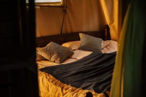 a bed with two pillows and a laptop on it at Hof ter Pierlapont Brugge by Feather Down in Zedelgem