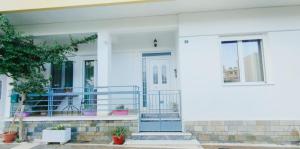 a white house with a blue front door at Anna's Cozy Place in Sparta