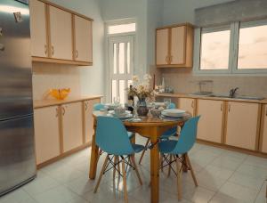 a kitchen with a wooden table and blue chairs at Anna's Cozy Place in Sparta
