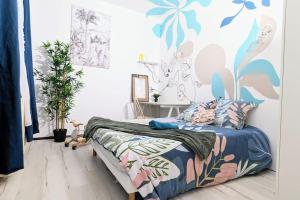 um quarto com uma cama com um padrão azul e rosa em Cosy Eden - 2 CH - Parking Free em Pau