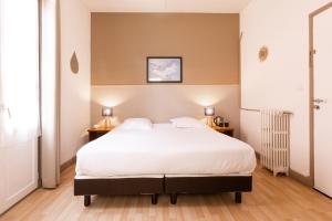 a bedroom with a large white bed and two lamps at Villa Sainte Anne in Porquerolles