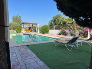 una piscina con tavolo e sedia accanto di Hacienda El chorlo a Cordoba