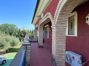 un edificio rosso con un passaggio esterno di Hacienda El chorlo a Cordoba