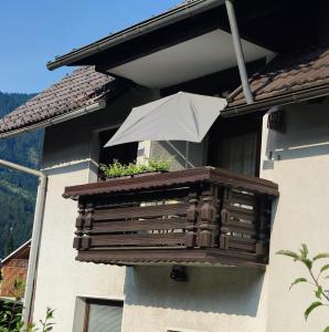 een balkon met een paraplu en een plantenbak bij Apartma 198 in Kranjska Gora