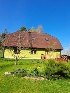 een geel huis met een rood dak in een tuin bij Kõrgemäe puhketalu in Eoste