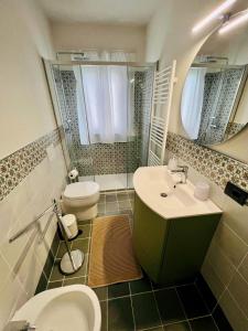 bagno con lavandino, servizi igienici e specchio di La Casina di Susy a Seravezza