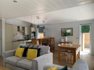 un soggiorno e una cucina con divano e tavolo di The Retreat, Strawberryfield Park a Cheddar
