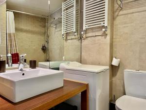 Baño blanco con lavabo y aseo en Monastiraki Loft AthensApart en Atenas
