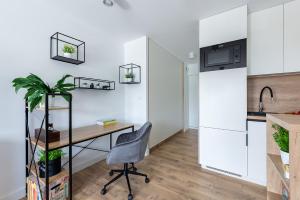 een keuken met een bureau en een stoel bij Wrzeciono 12 - Piękny apartament obok Szpitala Bielańskiego oraz AWF, bezpłatna strefa parkowania - 400m do stacji metra - Good Apartments in Warschau