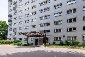 een groot wit gebouw met een luifel ervoor bij Wrzeciono 12 - Piękny apartament obok Szpitala Bielańskiego oraz AWF, bezpłatna strefa parkowania - 400m do stacji metra - Good Apartments in Warschau