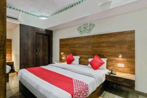 a bedroom with a large bed with red pillows at Collection O HOTEL TULIP PALACE in Jaipur