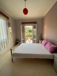 a bedroom with a bed with pink pillows at Marble's Residence in Argostoli