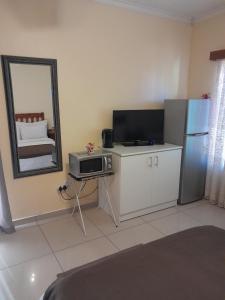 a living room with a microwave and a refrigerator at Eve's Accommodation in Windhoek