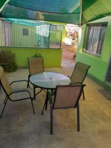 un patio con tavolo e sedie di fronte a un edificio di Eve's Accommodation a Windhoek