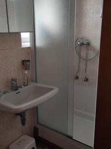 a bathroom with a sink and a shower and a toilet at Appartamento vista sul lago in Musignano