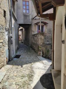 an alley in an old stone building with a window at Appartamento vista sul lago in Musignano