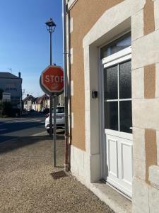 un panneau d'arrêt devant un bâtiment dans l'établissement LE VINTAGE DEOLOIS - proche aéroport - spacieux, à Déols
