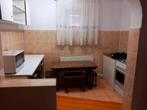 una pequeña cocina con mesa y microondas en Casa Simerea, en Mălini