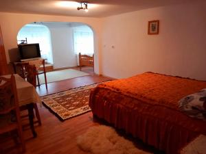 a bedroom with a bed and a dining room at Casa Simerea in Mălini