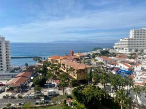 an aerial view of a city with buildings and the ocean at Lookout Point Tenerife Holiday Apartment Las Americas in Playa Fañabe