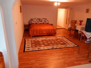 ein Schlafzimmer mit einem Bett und einem Teppich auf einem Holzboden in der Unterkunft Casa Simerea in Mălini